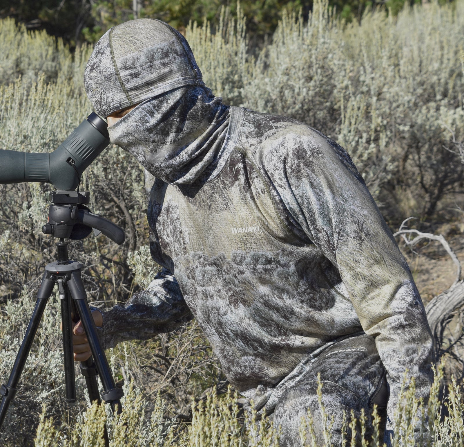Co Founder Luke Ripepi wearing Wanayi sage american made camouflage looking through a spotting scope 