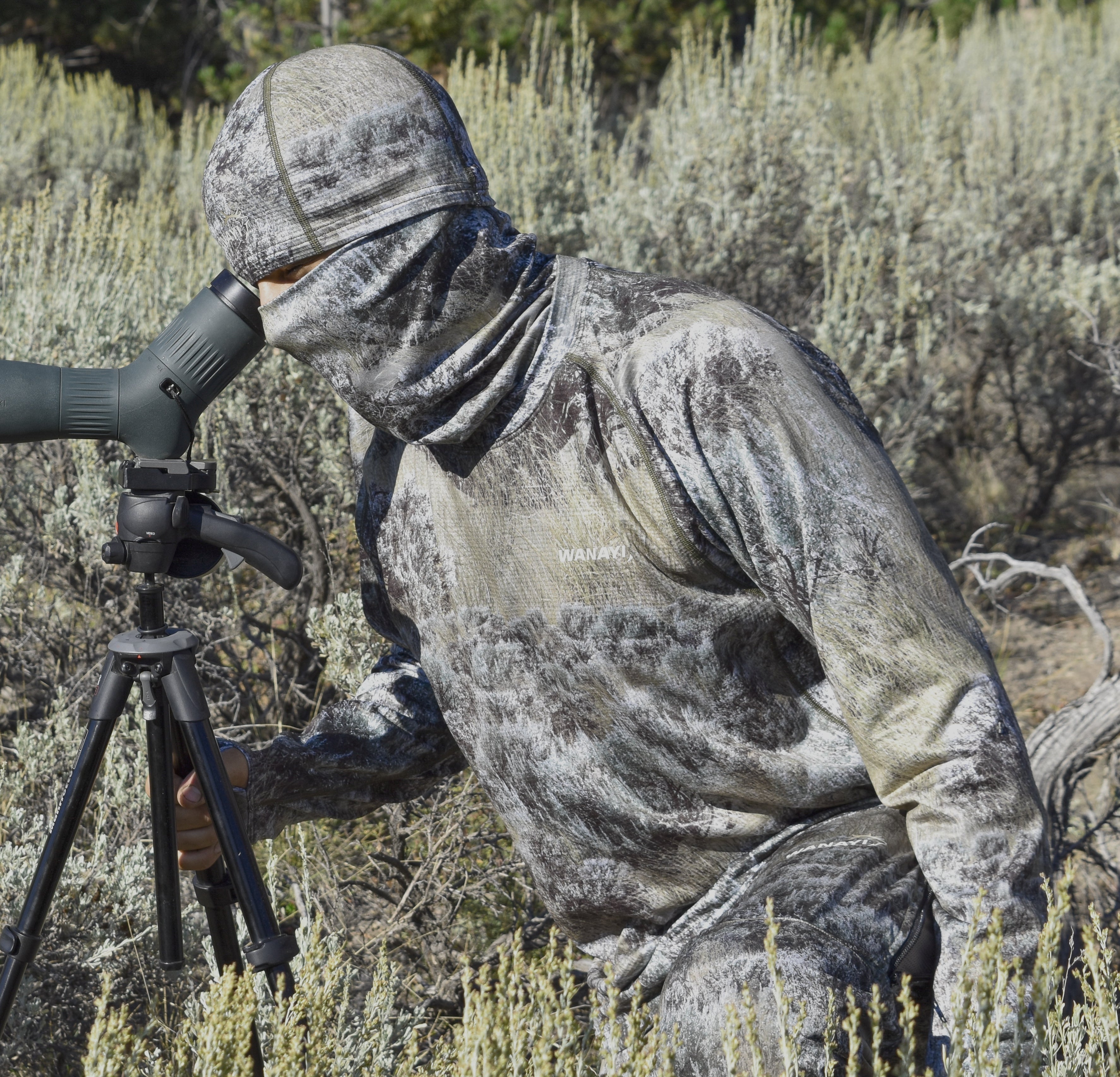 Co Founder Luke Ripepi wearing Wanayi sage american made camouflage looking through a spotting scope 